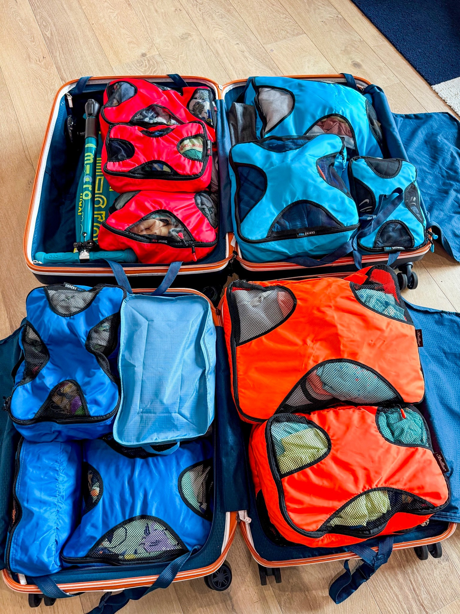 Family luggage organized with color coded packing cubes